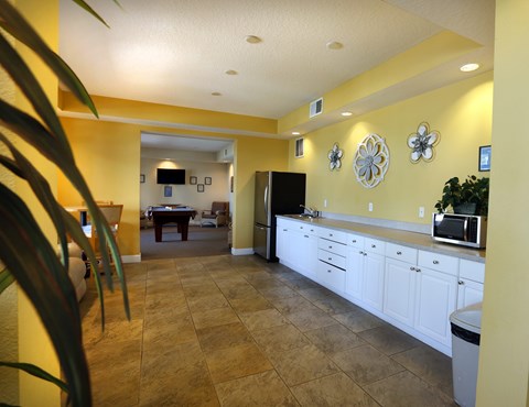 a kitchen and living room with a table and a refrigerator